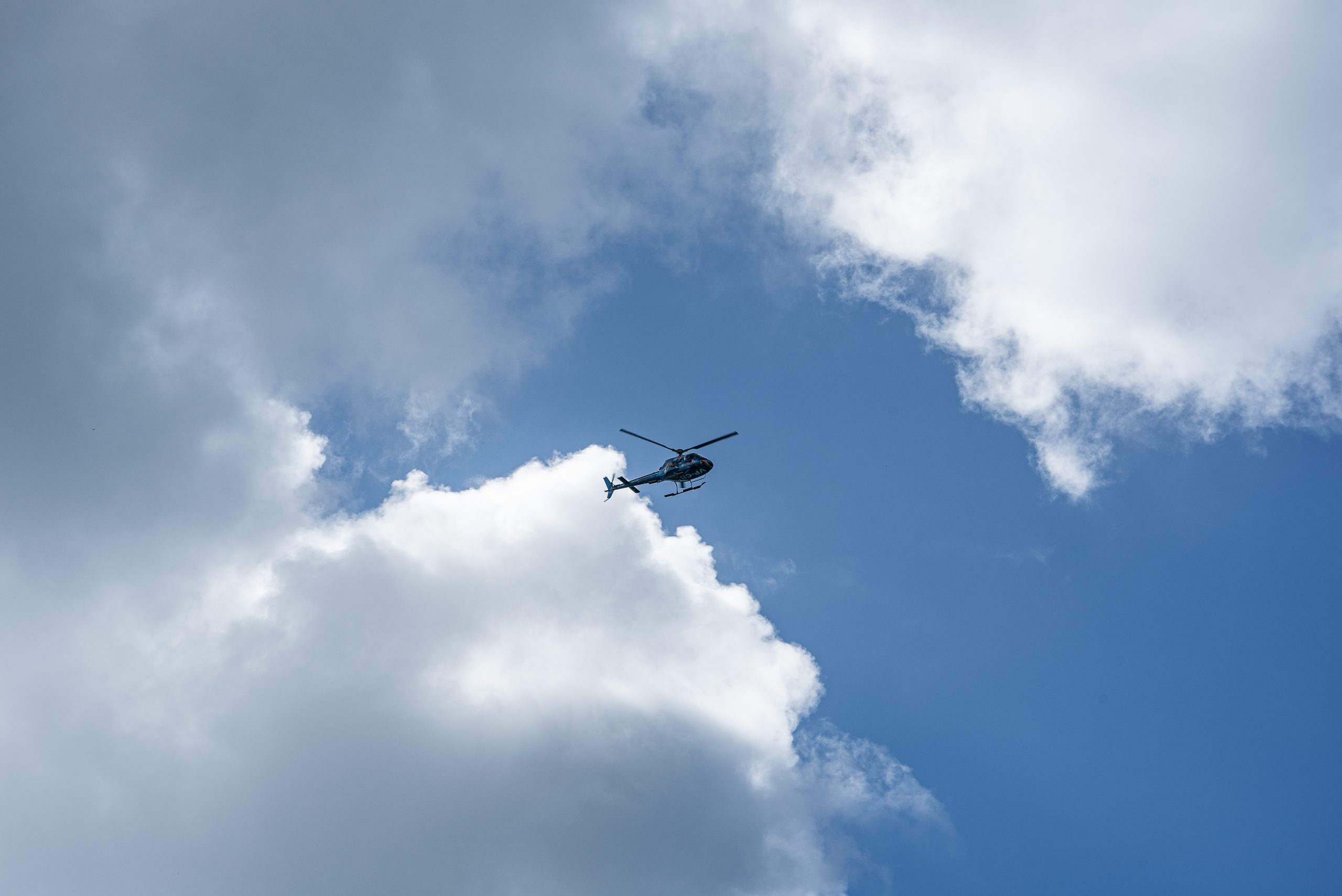 A low angle shot of a helicopter in the cloudy sky